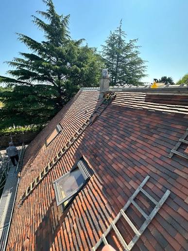 Chantier de rénovation de toiture en tuiles plates avec échafaudage et échelles de couvreur